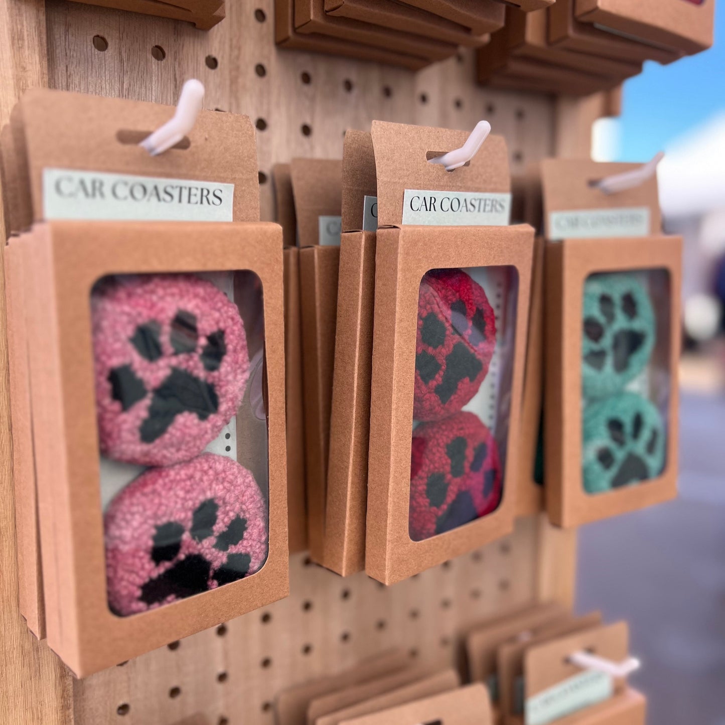 Pairs of coasters sold in cardboard packaging with clear window to see them