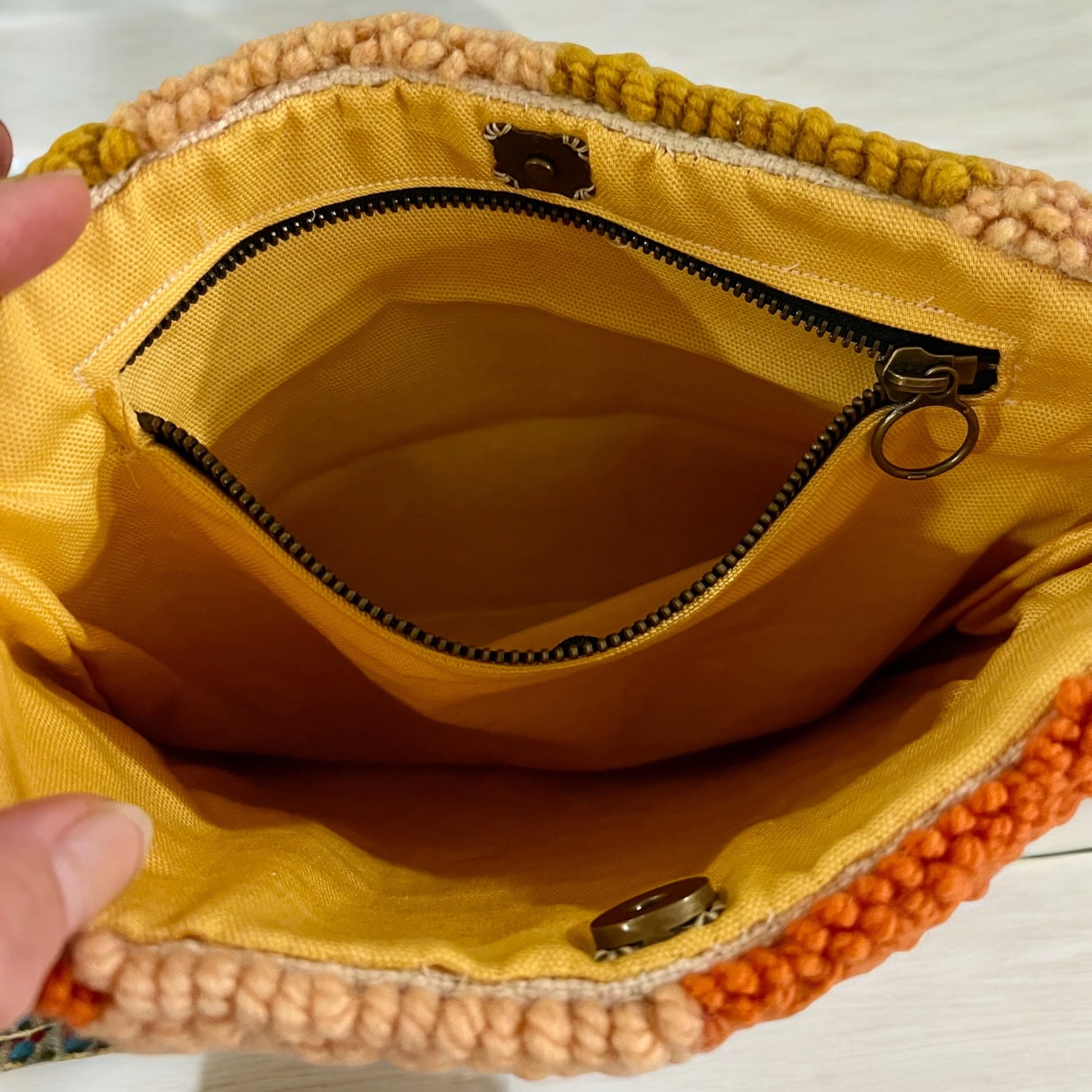 pocket is made with same yellow fabric as inside of handbag