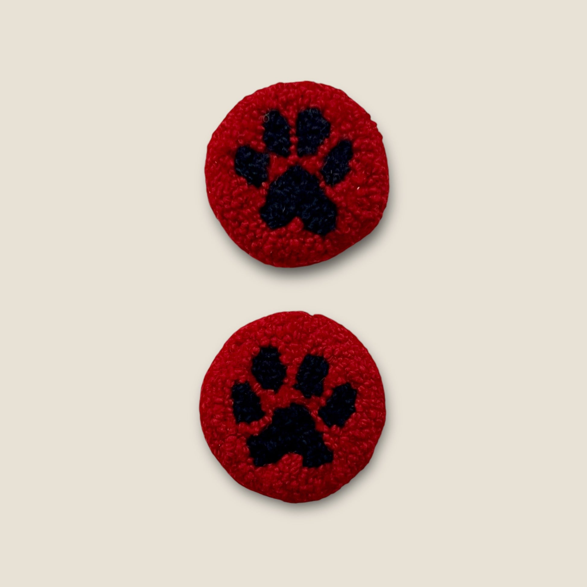 coasters made with black wool for paw and red wool for background
